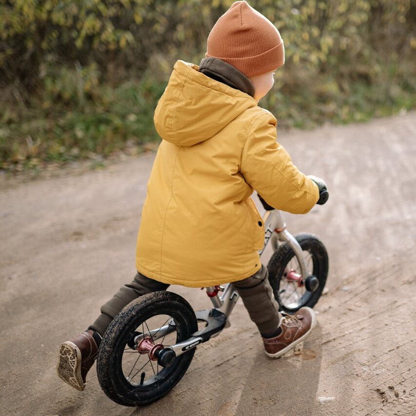 Copil pe o bicicletă fără pedale