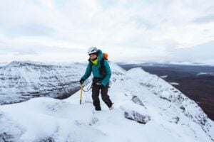 alpinist cu piolet pe traseu montan de iarna